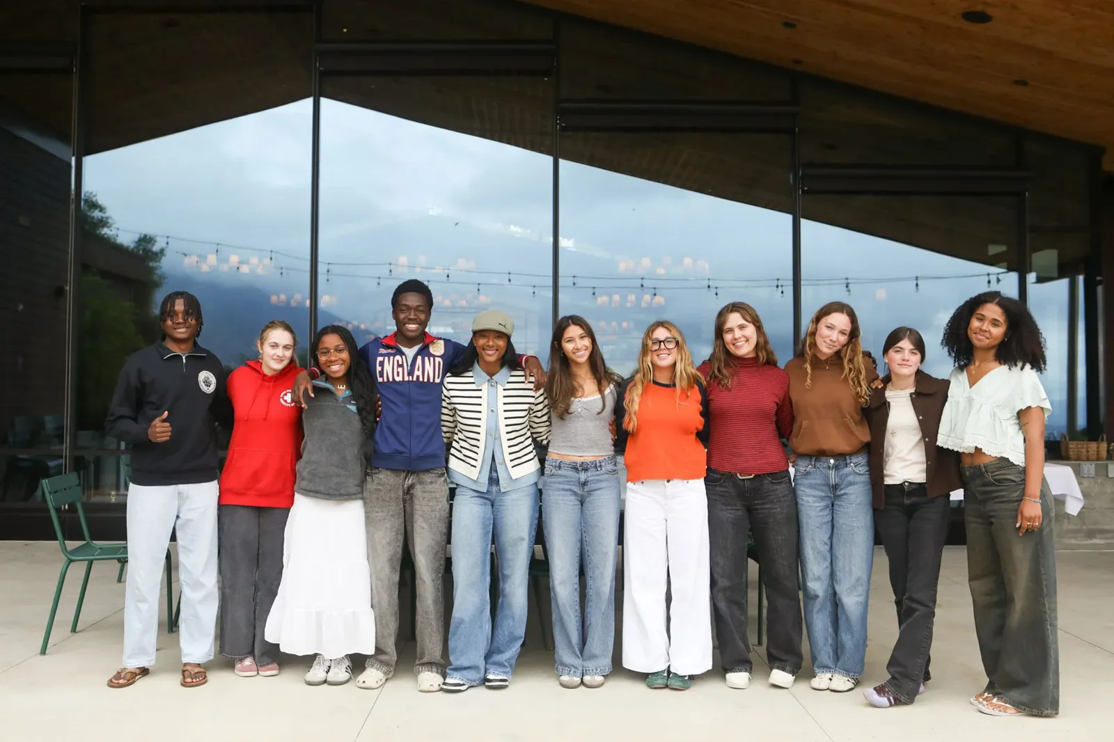 Blake Bolden standing with a group of students in front of tall windows